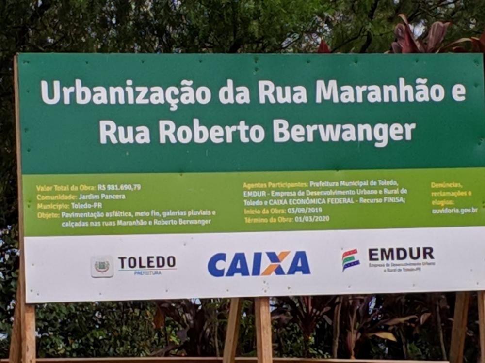 #Pracegover. Fotografia. Placa indicando as obras de urbanização.